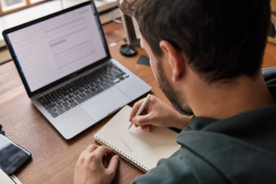 Desk with a laptop and a handwritten removal checklist