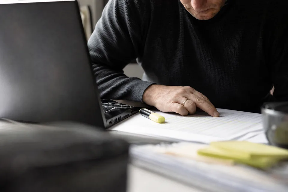 Highlighted rows of a printed report next to a laptop table