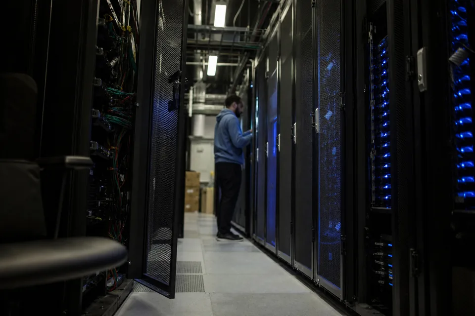Data center corridor with server racks and a technician