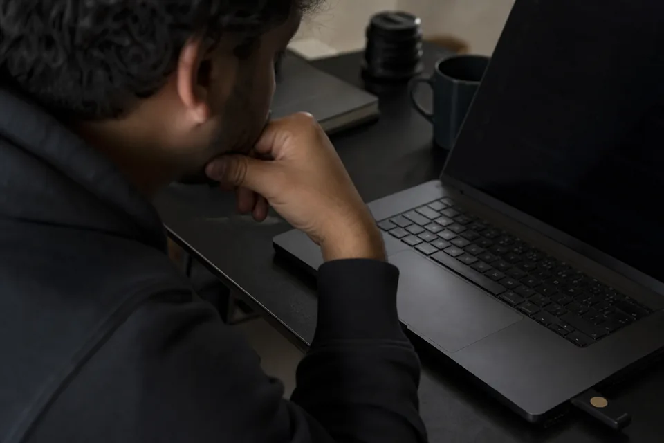 Laptop with a hardware security key in a dim workspace